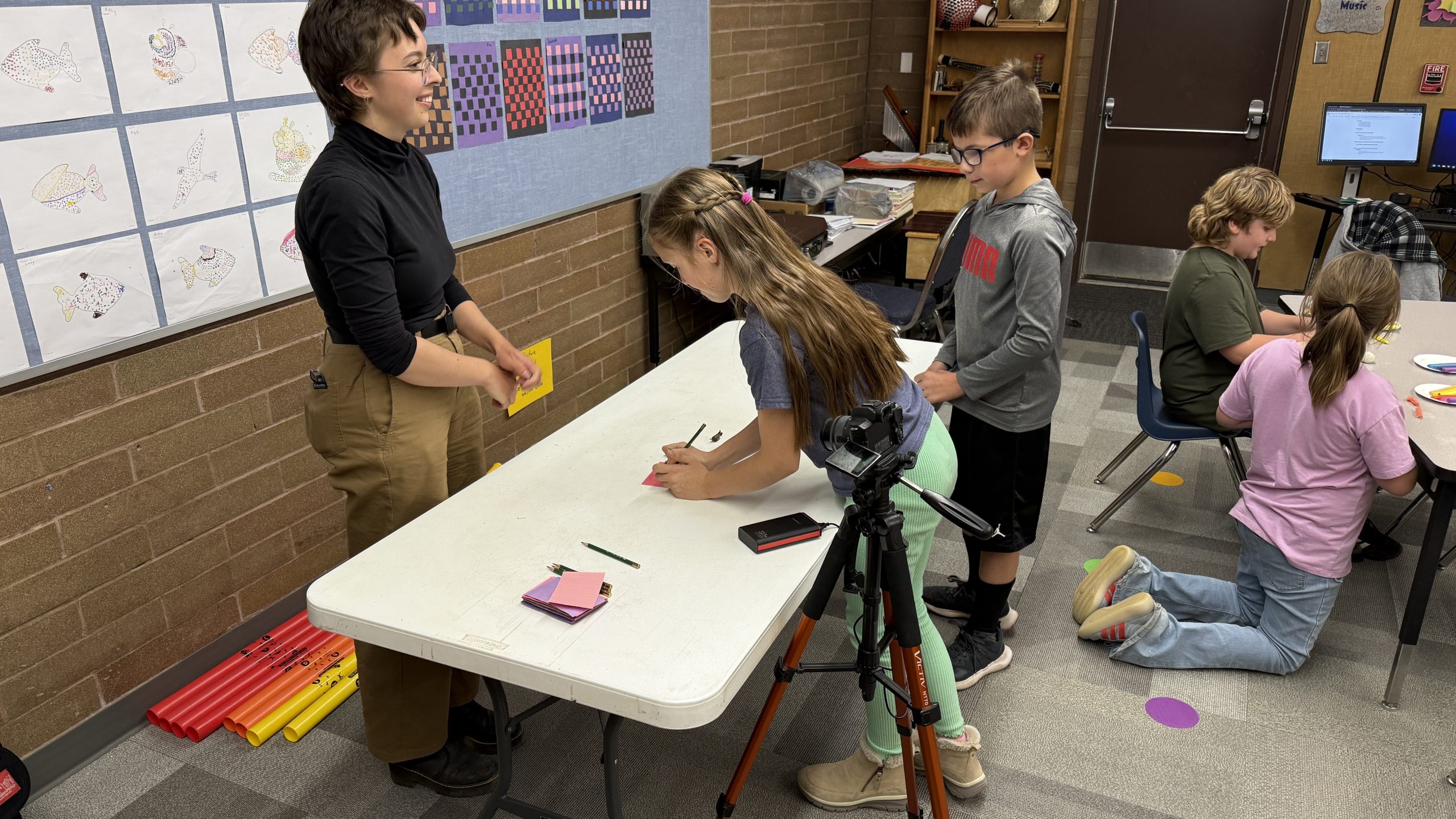 Lumi Barron working with students on stop-motion projects using clay.